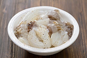 Squids in white plate on brown background