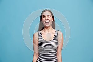 The squint eyed woman with weird expression isolated on blue photo
