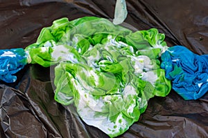 Squished green and blue tie dye shirt with wet dye for children`s creative and artistic concepts photo