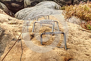 Srew with steel rope anchored into rocky wall