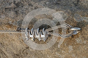 Srew with steel rope anchored into rocky wall