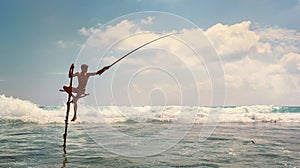 Sri lanka traditional `stick`- method fish catching Fisherman in the Indian Ocean waves.