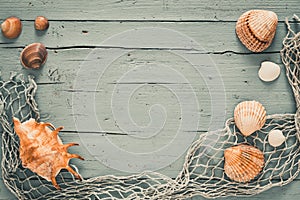 Sseashells and fishing net on old grey wooden background