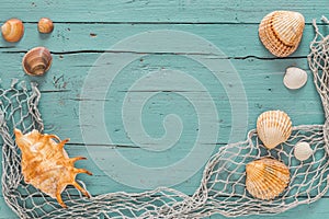 Sseashells and fishing net on turquoise wooden background