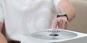 SSTK Technology. User adjusting air purifier settings with smartphone.