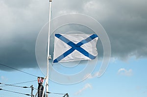 The St. Andrew`s flag is flying in a strong wind. The St. Andrew`s Banner is a symbol of naval military forces. White cloth
