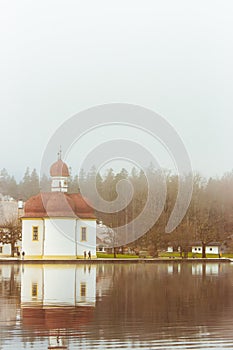 St. Bartholomews church in the morning fog, Konigsee lake, Bavaria, Germany. Alpine lake with church on the bank.