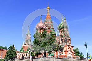 St. Basil`s Cathedral on Red square against Moscow Kremlin on a sunny summer morning