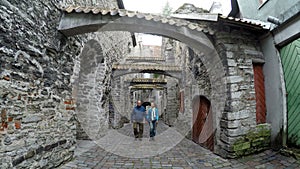 St. Catherine Passage little walkway in the old city Tallinn, Estonia,man and the woman go having joined hands