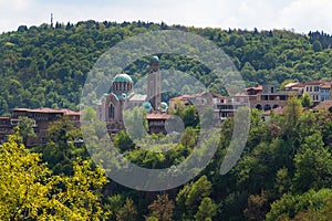 St Demetrius orthodox cathedral in Veliko Tarnovo city, Bulgaria. Tourist attraction surrounded by trees and mountain