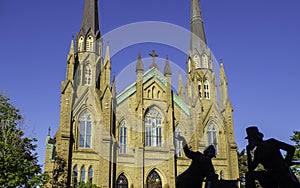 St. Dunstan`s Basilica Cathedral and the bronze statue of two Fathers of Confederation in the sunny day in Charlottetown