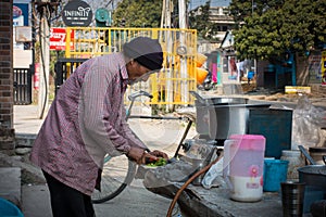 21st february 2021. Dehradun, Uttarakhand, India. A roadside poor tea and snack stall vendor cutting vegetables for cooking in