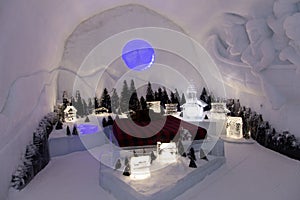 Bedroom in the world-renowned seasonal Ice HotelÃ¢â¬â¢s on the theme of a small village illuminated in white