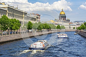 St. Isaac`s cathedral and cruise boats on Moyka river, Saint Petersburg, Russia