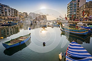 St.Julian`s, Malta - Sunrise at Spinola Bay with Traditional maltese fishing boats