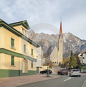 St. Laurentius New Parish Church - Schaan-Vaduz, Liechtenstein. Fragment of a city street. In the background - the snow-capped pea