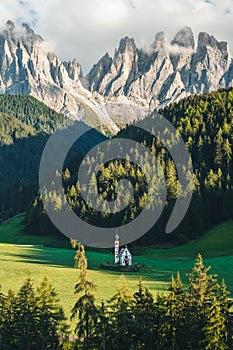 St Magdalena church in Val di Funes valley, Dolomites, Italy. Furchetta and Sass Rigais mountain peaks in background