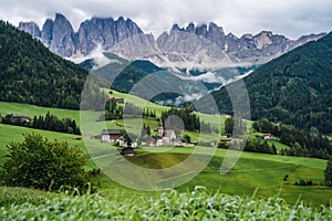 St Magdalena church in Val di Funes valley, Dolomites, Italy. Furchetta and Sass Rigais mountain peaks in background