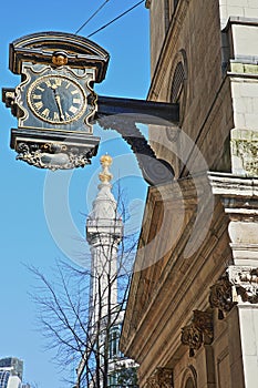 St Magnus the Martyr Church in the financial district of the City of London with a clock on the left side and the Monument to the