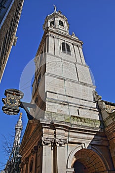 St Magnus the Martyr Church in the financial district of the City of London with a clock on the left side and the Monument to the
