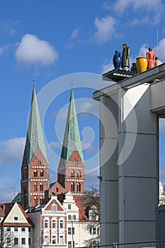 St. Mary`s Church or Marienkirche with two towers and the sculptures called Strangers on the roof of the Music and Congress Hall