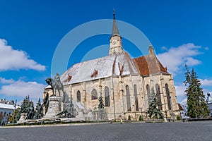 St. Michael`s Church and Matthias Corvinus Monument in the city center of Cluj-Napoca, Romania during a sunny day with blue sky
