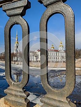 St. Nicholas Naval Cathedral belltower through the forged lattice in a clear sunny day of spring, an ice drift on