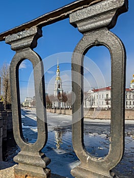 St. Nicholas Naval Cathedral belltower through the forged lattice in a clear sunny day of spring, an ice drift on