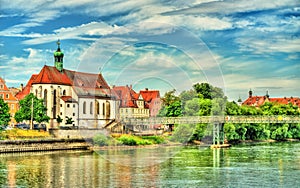 St. Oswald Church with Eiserner Steg bridge across the Danube River in Regensburg, Germany photo
