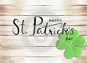 Happy St. Patrick`s Day Black Text Typography Background with Green Shamrocks on Wooden Texture