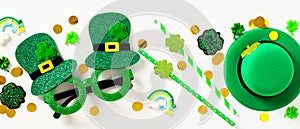 St Patrick`s Day banner. Flat lay party glasses, drinking straws, leprechauns hat, confetti on white background