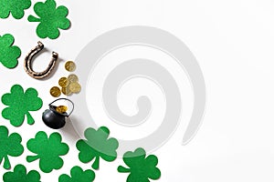 St. Patrick's day black pot with coins on green background.