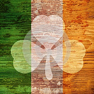 St. Patrick`s Day. Bright spot in the form of a shamrock on the wooden surface of the Irish flag colors