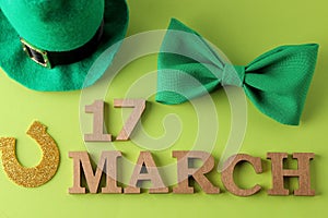 St.Patrick `s Day. celebration. A green bow tie, a leprechaun hat and a horseshoe and the text of March 17 on a bright green back