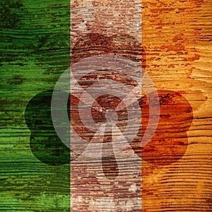 St. Patrick`s Day. Dark spot in the form of a shamrock on the wooden surface of the Irish flag colors