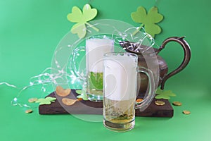 St. Patrick's Day, fresh beer in glass mugs and a bottle, gold coins, on a red wooden table