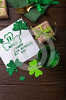 St. Patrick`s Day Green Beer pint over dark green background, decorated with shamrock leaves. Patrick Day pub party, celebrating