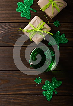 St. Patrick`s Day Green Beer pint over dark green background, decorated with shamrock leaves. Patrick Day pub party, celebrating