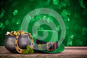 St Patrick`s Day hat and pot with gold coins on green twinkling bokeh background