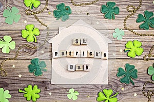 St.Patrick`s day home symbol with clover leafs on wooden backgro