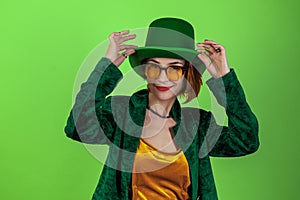 St. Patrick`s Day leprechaun model woman. Beautiful smiling woman wearing green hat. Green background