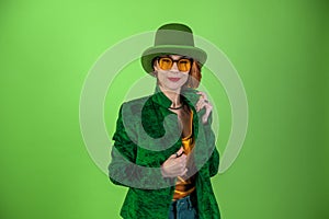 St. Patrick`s Day leprechaun model woman. Beautiful smiling woman wearing green hat. Green background