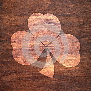 St. Patrick`s Day. Shamrock-shaped light spot on a wooden surface