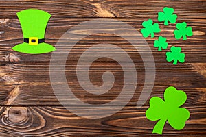 St. Patrick`s Day theme colorful horizontal banner. Green leprechaun hat and shamrock leaves on brown wooden background. Felt cra