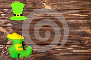 St. Patrick`s Day theme colorful horizontal banner. Green leprechaun hat and shoe with gold on brown wooden background. Felt cref