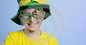 St. Patricks day banner. Portrait of joyful kid in clover shaped glasses.