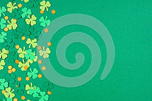 St Patricks Day green background with shamrock and gold coin confetti side border