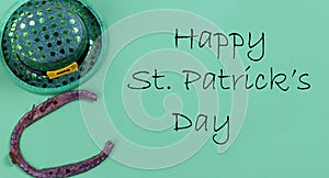 St Patricks day Irish good luck horse shoe and elf hat on a green paper background with copy space plus text