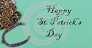 St Patricks day Irish good luck items with golden coins and horseshoe on a green paper background plus text