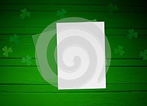 St. Patricks day mock up scene with envelope, blank paper, wooden background and clover leaves